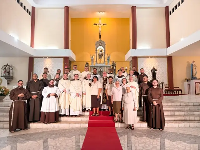 Foto oficial dos frades, clarissas e formandos diante do altar