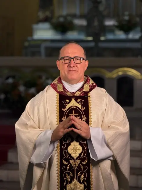 Frade com casula bordada diante do altar